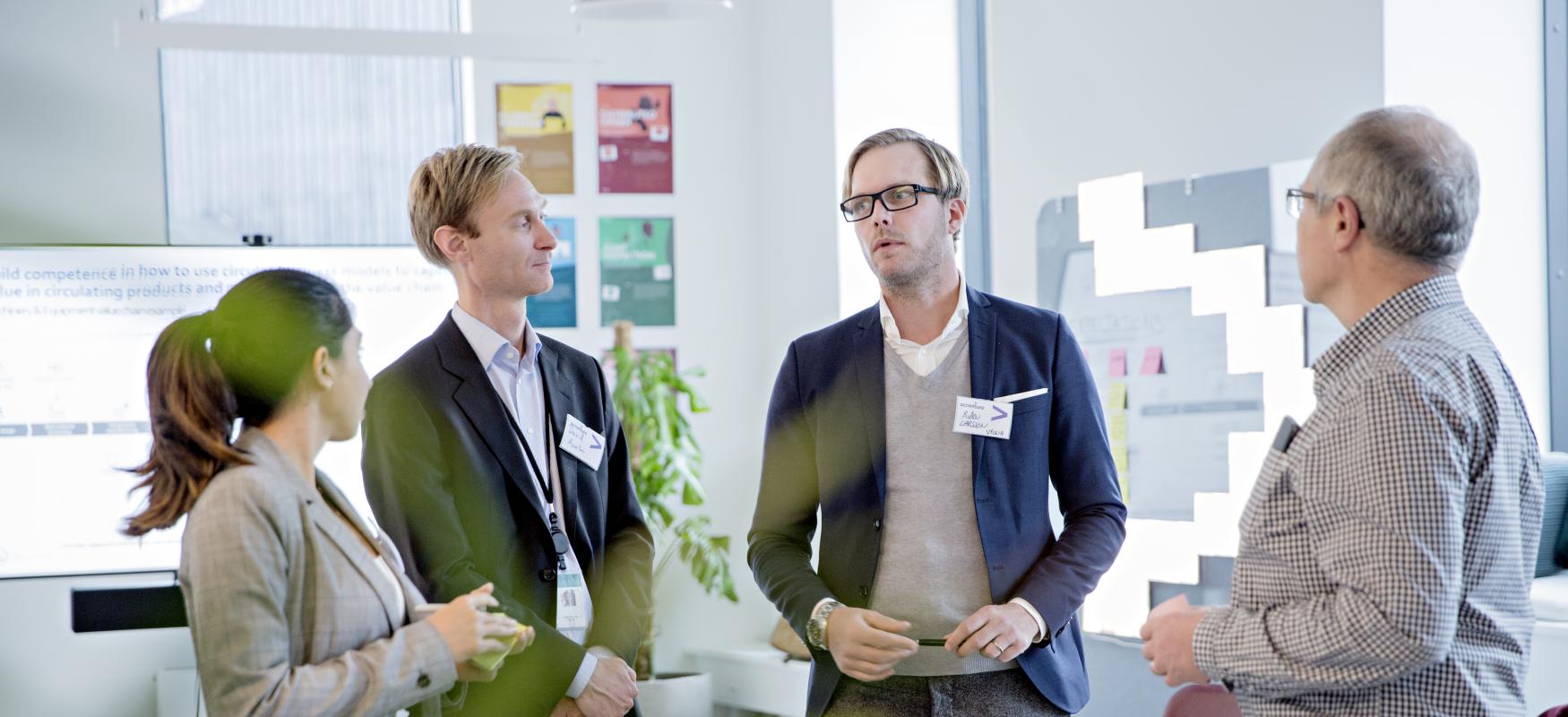 Group work, 4 people standing and discussing ideas