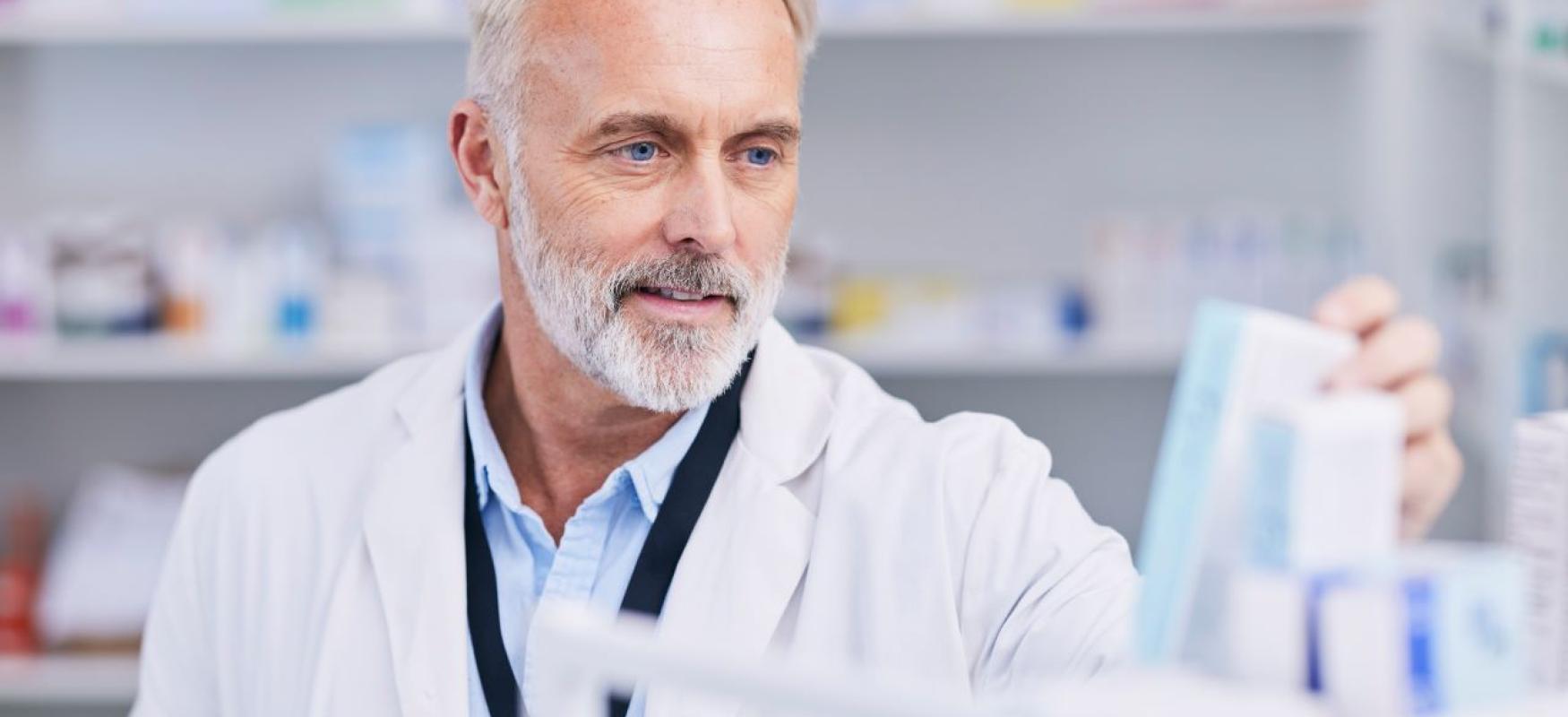 Mand kigger på en æske med medicin