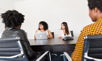 4 women sitting around a table
