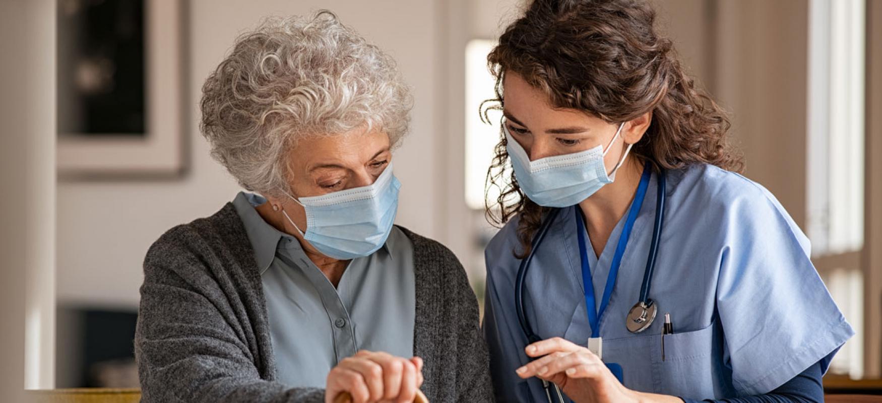 Elderly woman and nurse looking at a tablet