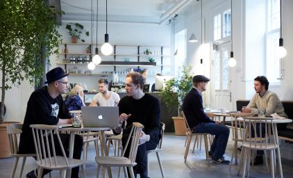 people sitting at tables in a cafe and working