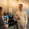 Joonas Lappänen talking to a colleague and enjoying a coffee 