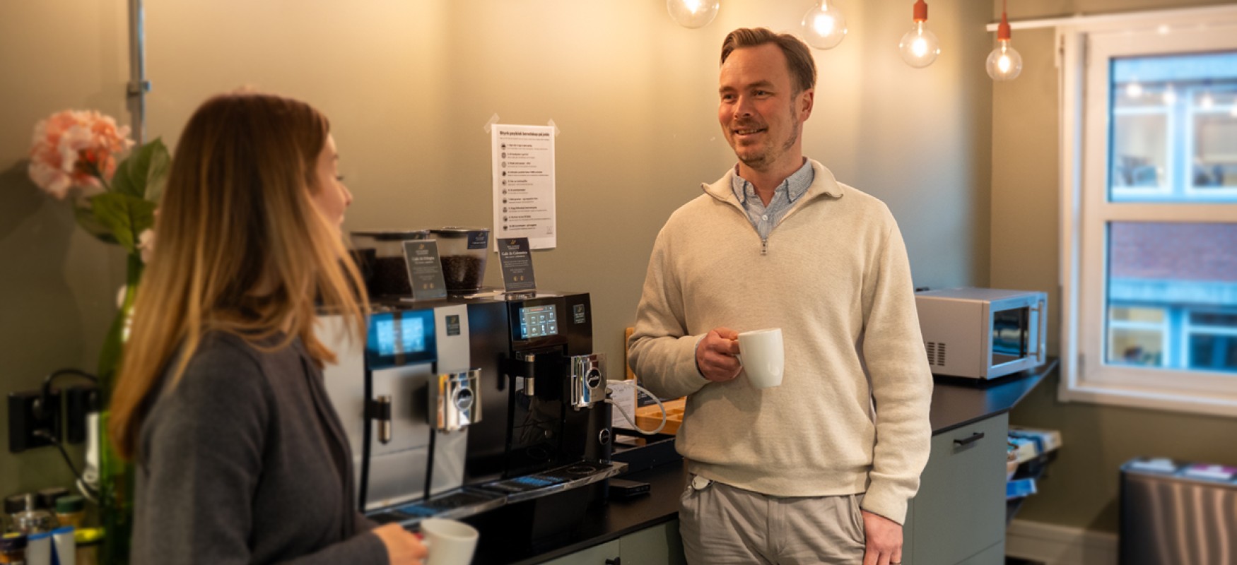Joonas Lappänen talking to a colleague and enjoying a coffee 