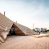 The wooden exterior of the Löyly sauna in Helsinki with the city in the background.