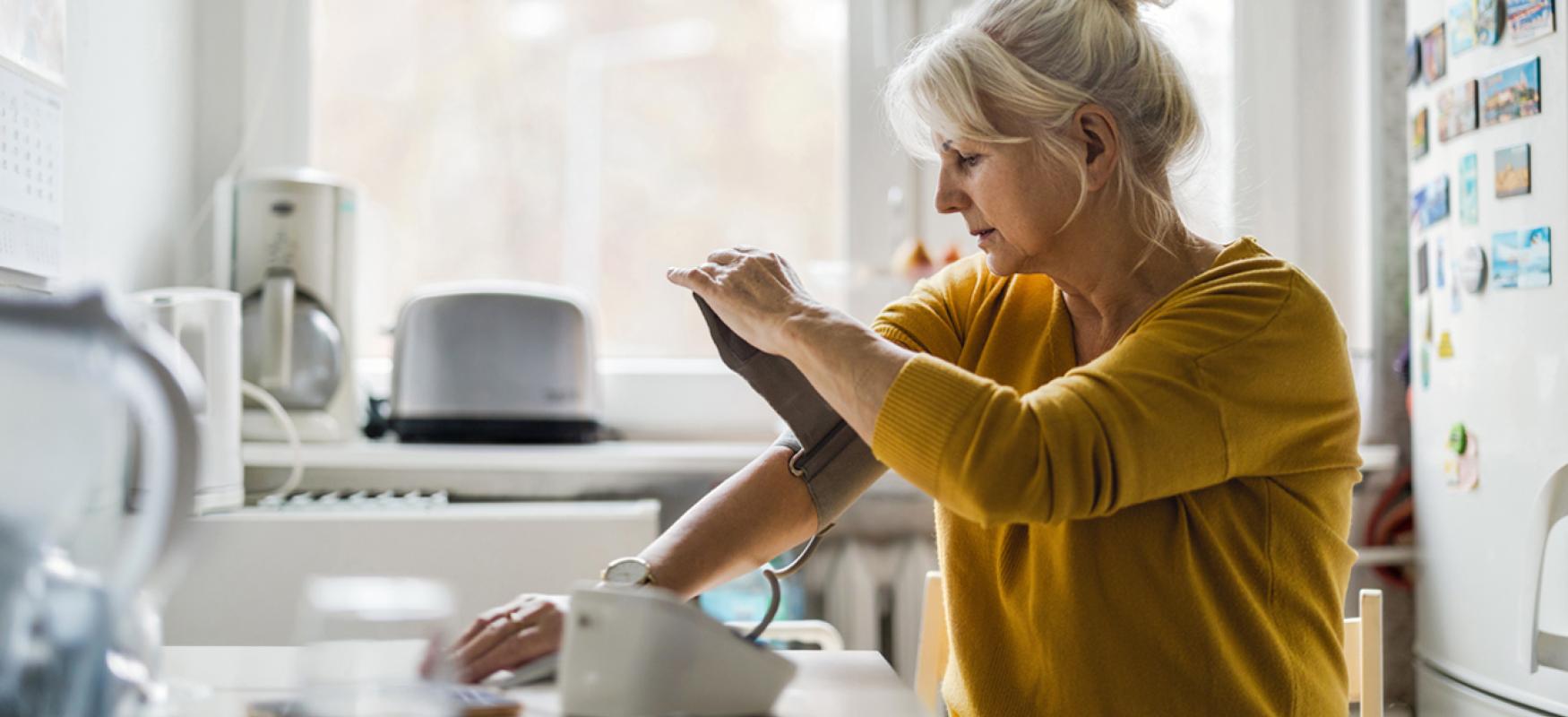Elderly women measuring her blood pressure on her own.