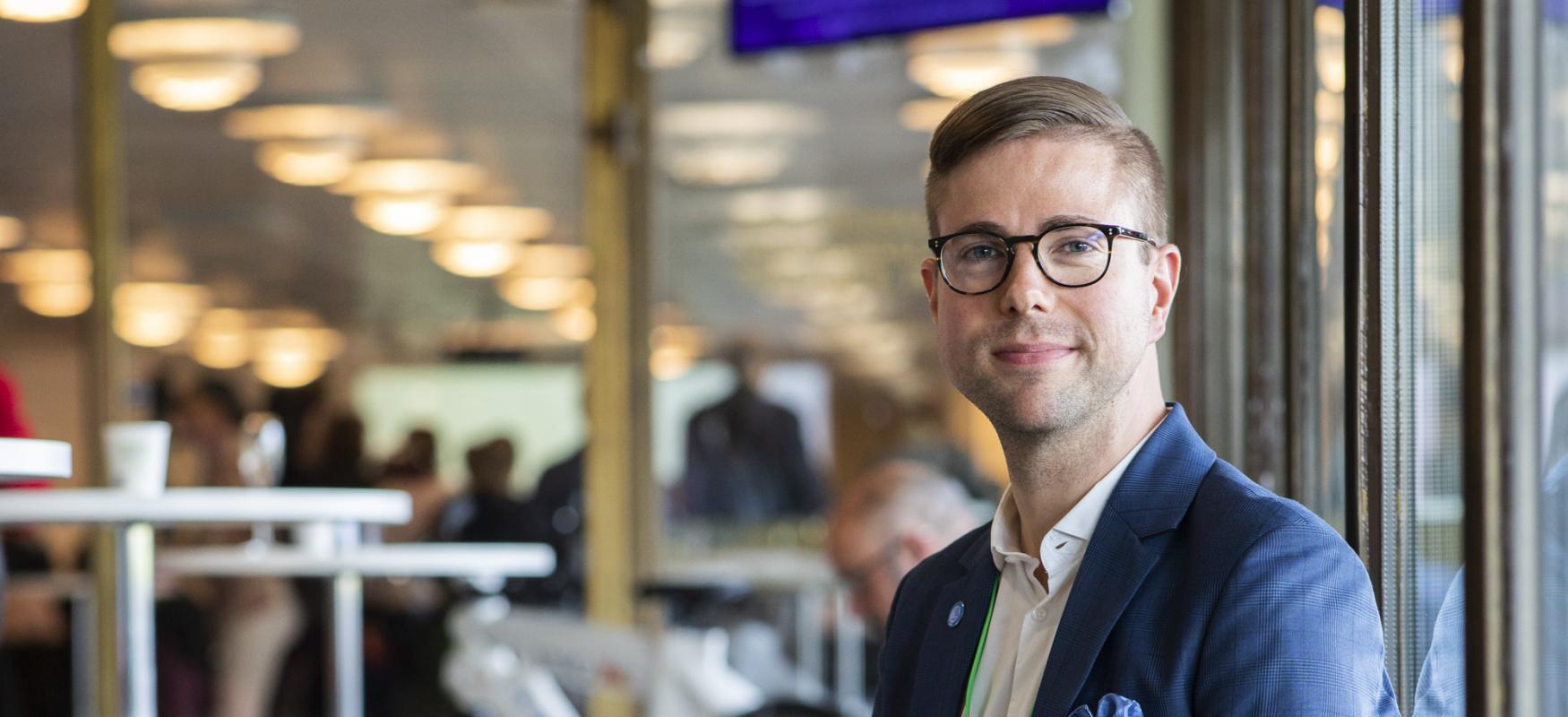 Elis Benediktsson sitting on a bench and smiling to the camera during WCEF2019 in Helsinki.