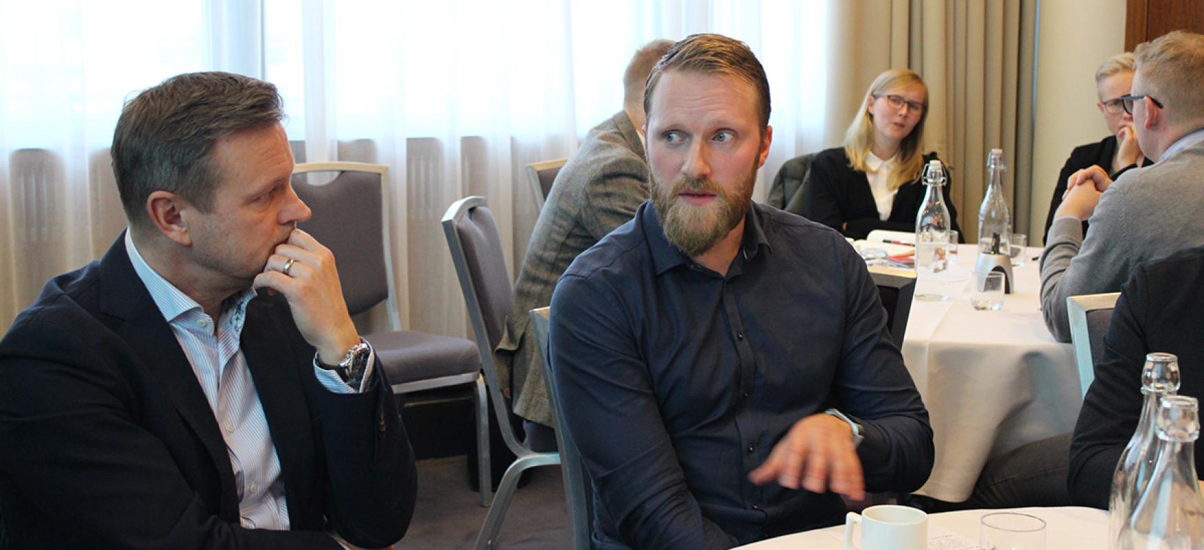 To men discussing at a the workshop in Iceland.